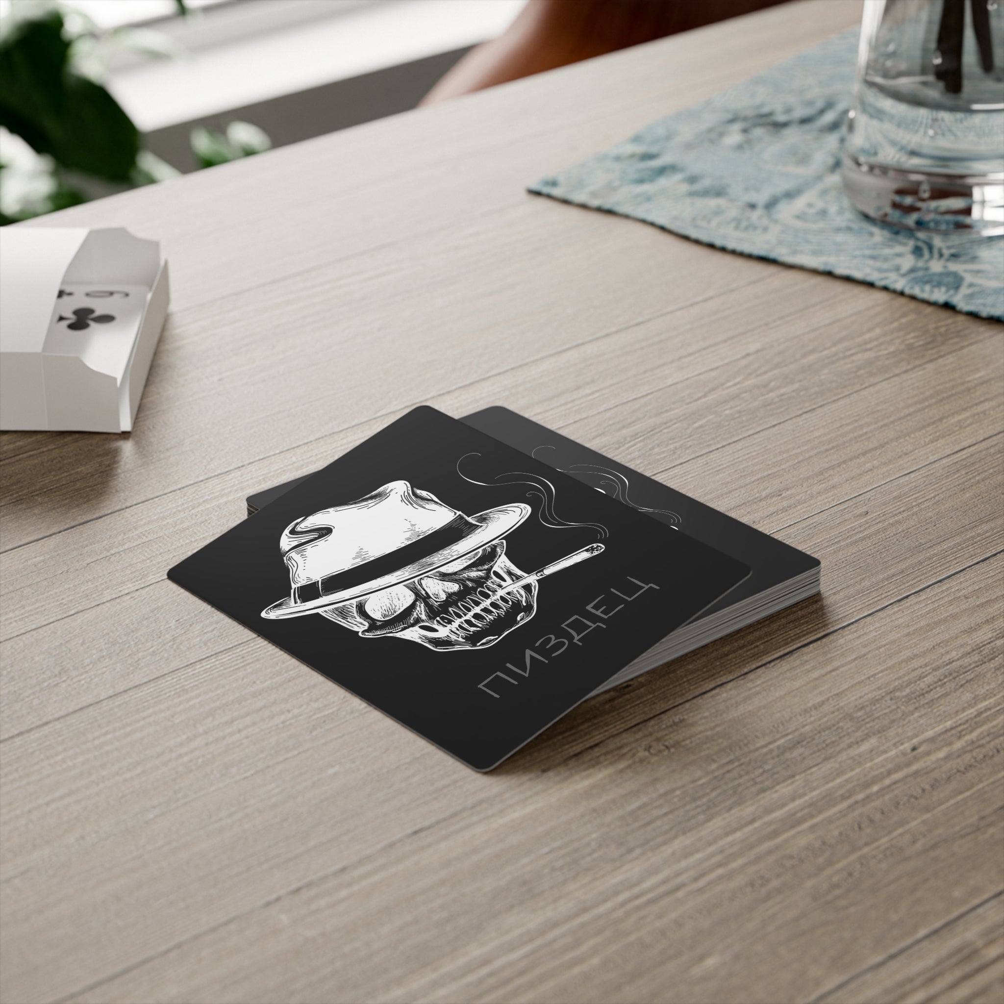 Kartenstappel von Zareno liegt auf einen Holztisch, Kartenstappel zeigt den Totenkopf und die Aufschrift in Kyrillischer Schrift Pisdez